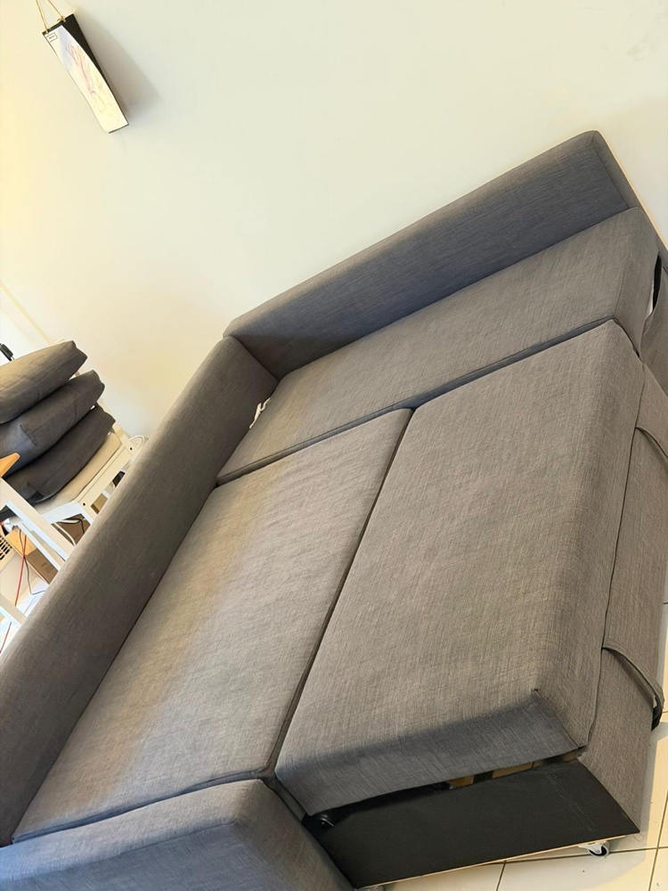 Grey sofa bed pulled out fully cleaned after steam cleaning