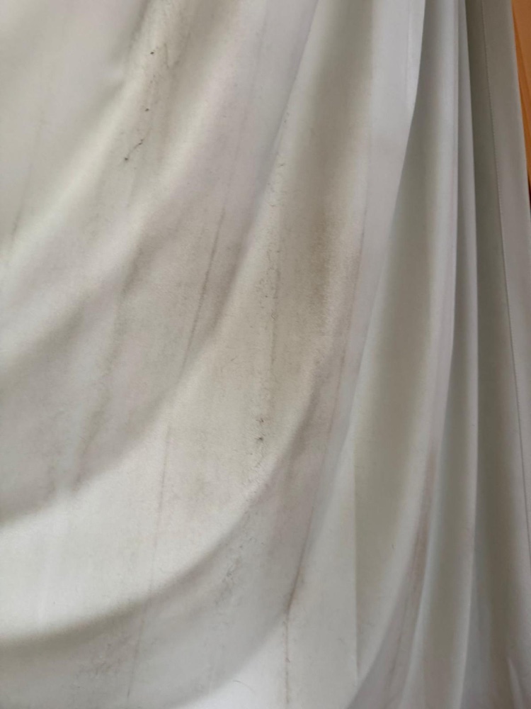 White curtain dulled with grime and marks before cleaning