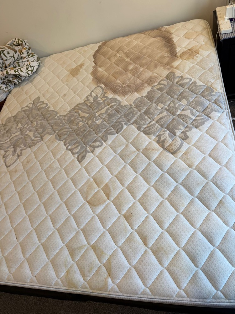 Mattress with large brown stains before cleaning