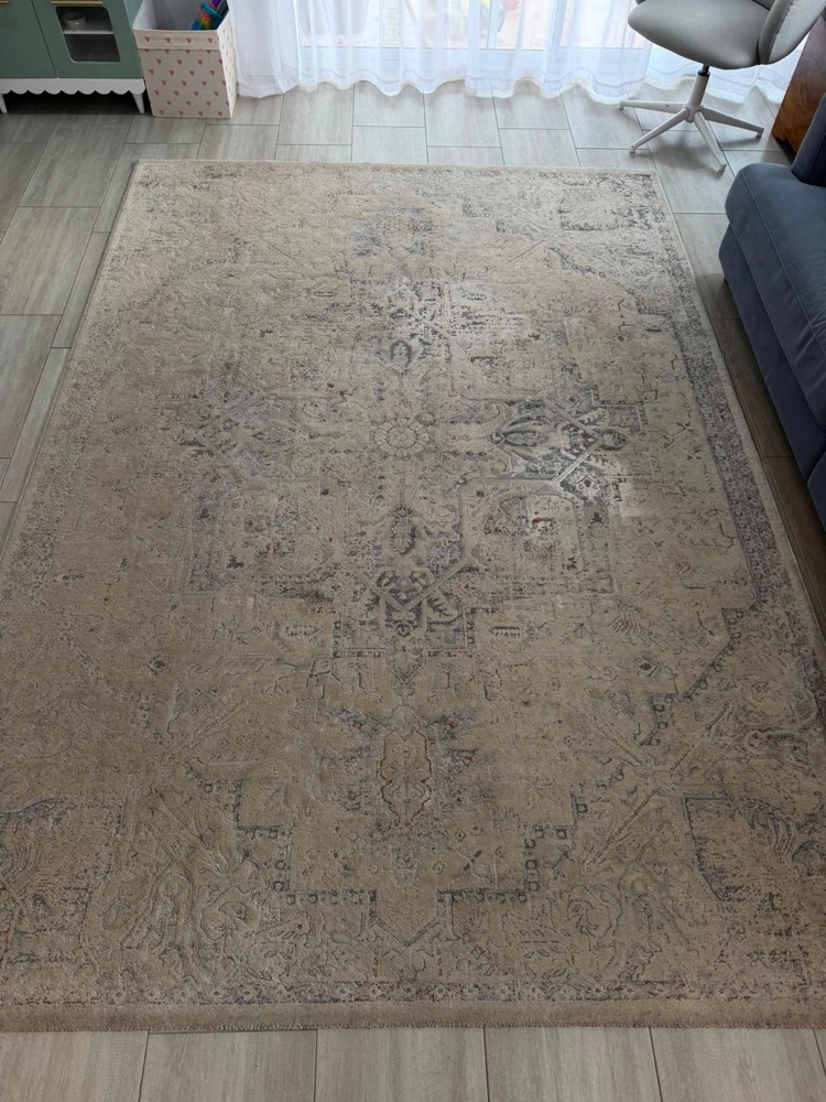 Dingy beige area rug before professional cleaning
